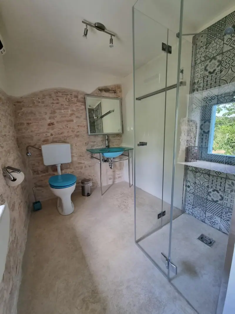 Bad beim Schlafzimmer mit Glasdusche, WC und Waschtisch