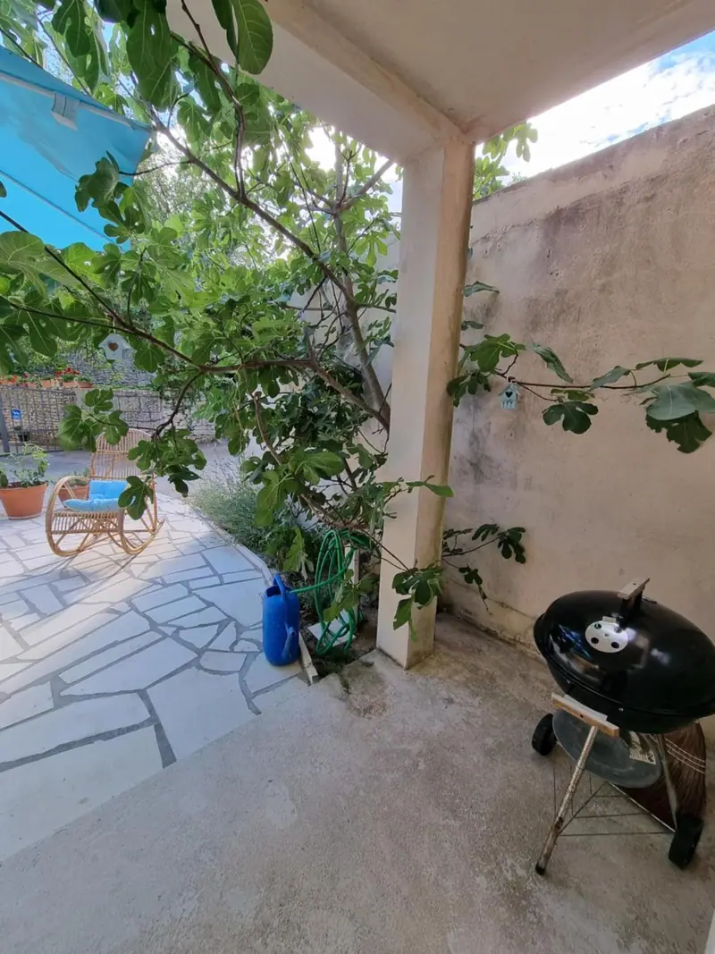 Überdachter Freisitz mit Grill neben dem Feigenbaum auf der Terrasse von Casa Bella