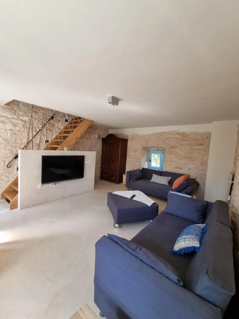 Wohnzimmer mit zwei Schlafsofas und TV-Wand