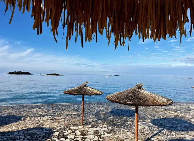 Beach with reed parasols and a view of the sea