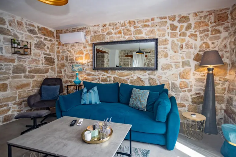 Living area with natural stone wall, sofa and coffee table