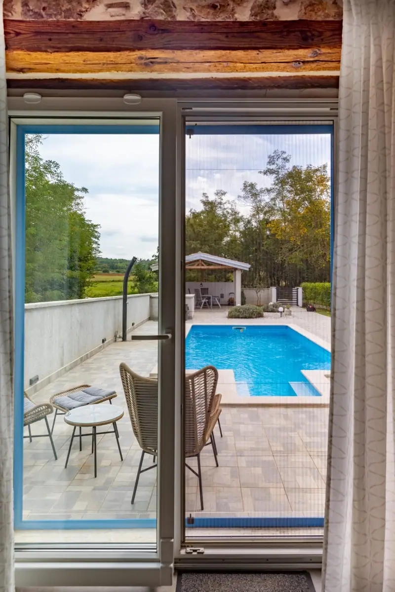 View through the terrace door to the pool and summer kitchen