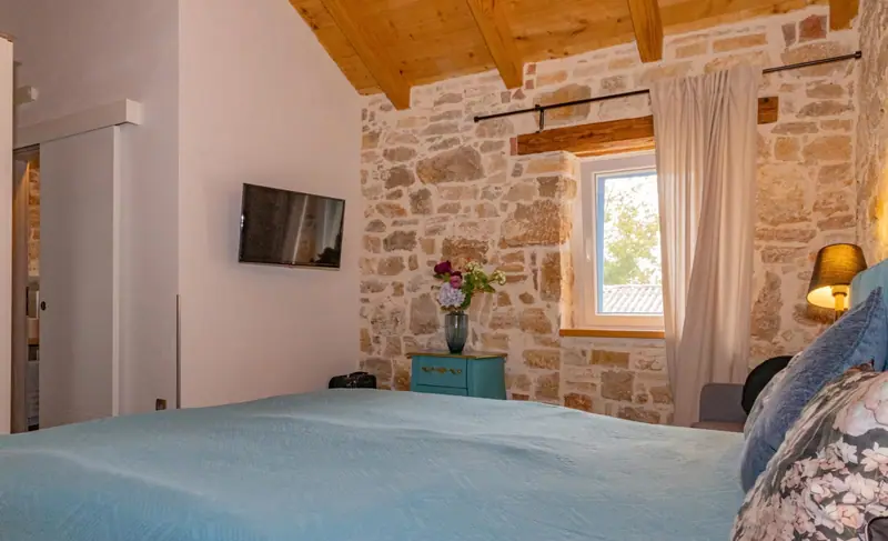 Bedroom with wooden ceiling and TV