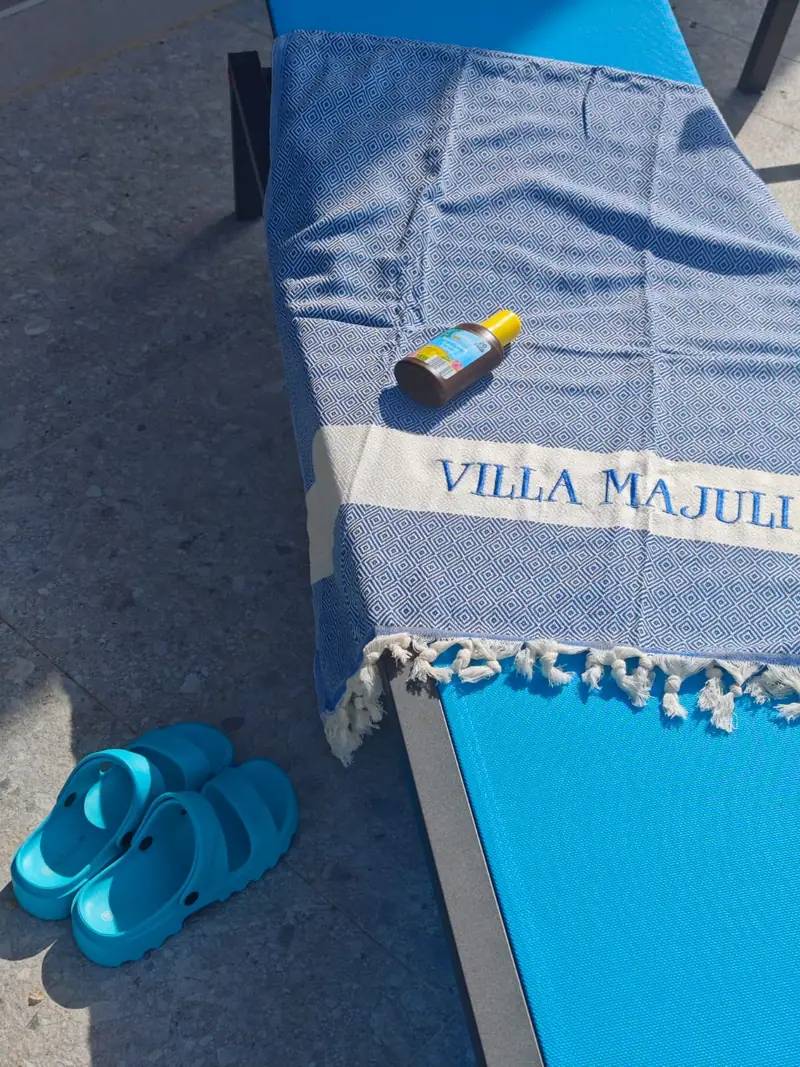 Bath towel with Villa Majuli lettering by the pool