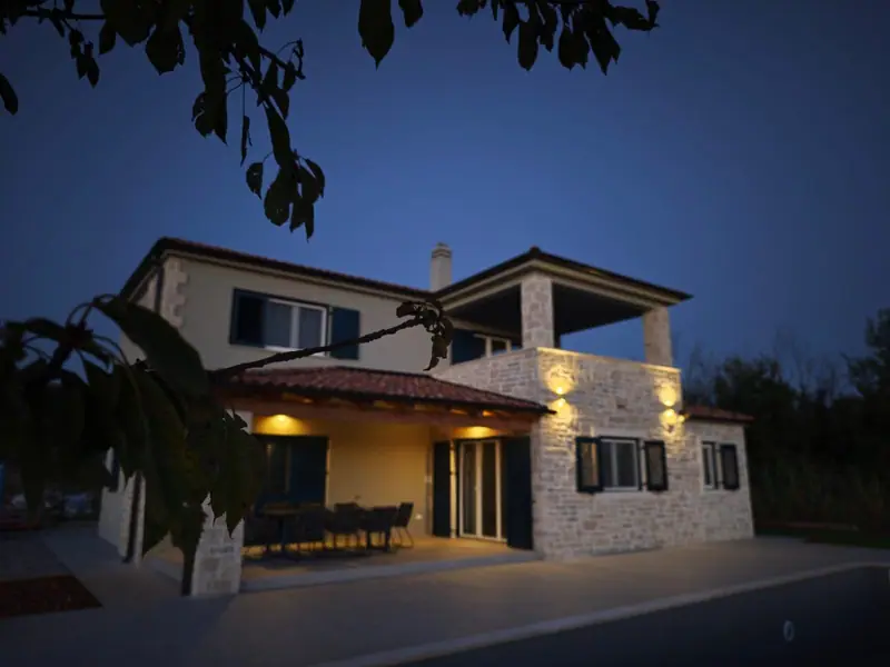The house in the evening with illuminated terrace