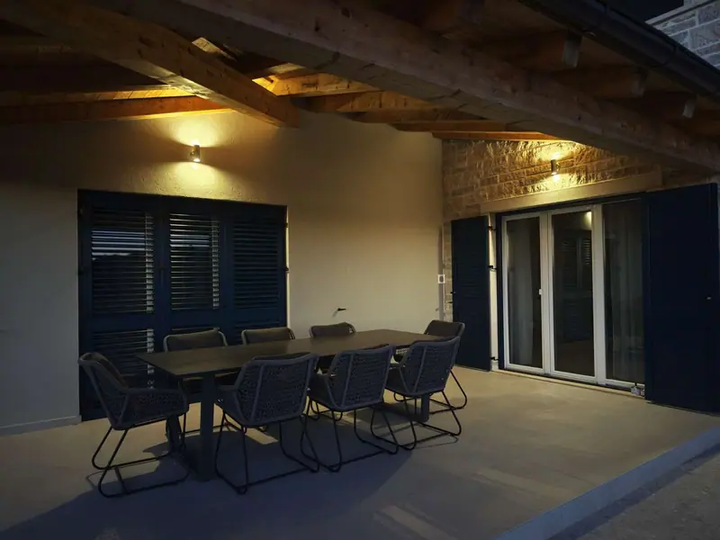 Covered terrace with dining table in the evening